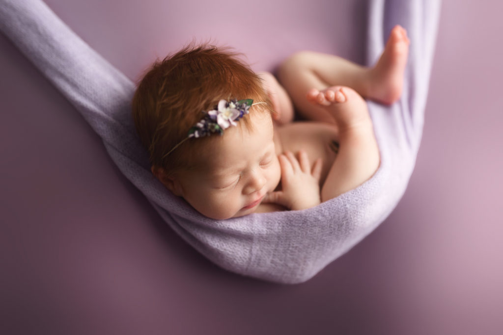 newborn baby in hammock shot purple